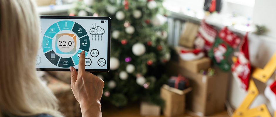 Έξυπνος έλεγχος σπιτιού σε tablet. Εσωτερικό του καθιστικού στο παρασκήνιο τα Χριστούγεννα